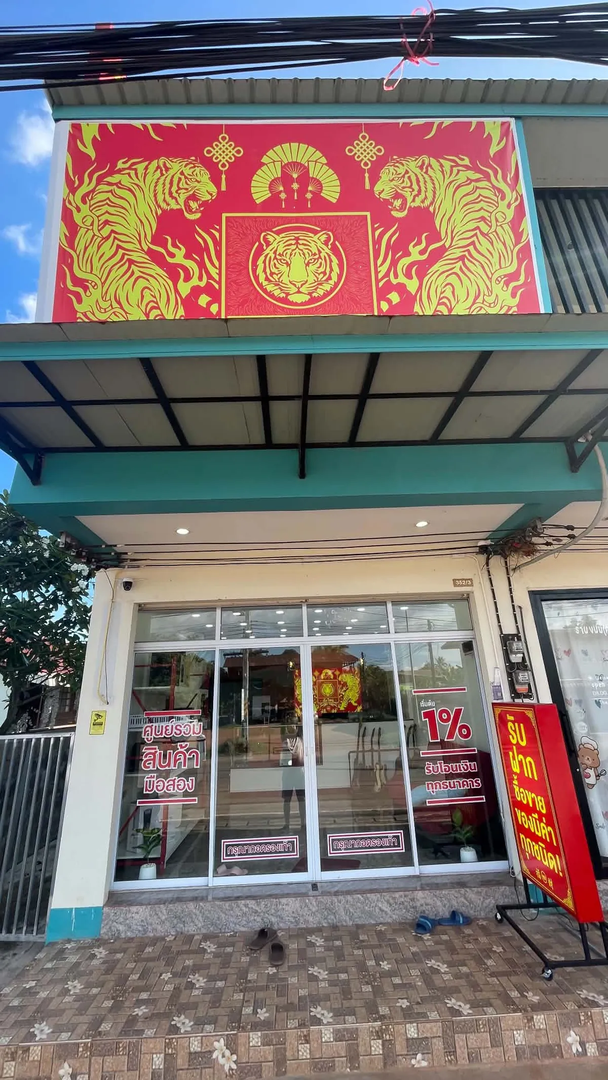 หน้าร้านเฮียใหญ่รับฝาก สาขาโพนพิสัย มีป้ายเสือแดงทองด้านบน