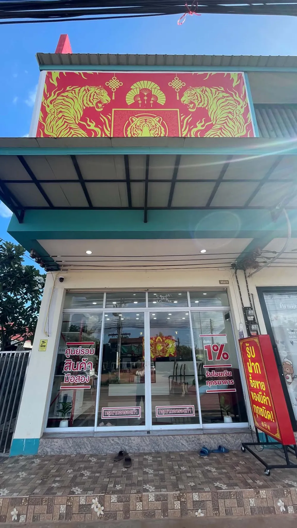 ป้ายเสือแดงทองหน้าร้าน มองเห็นจากถนน